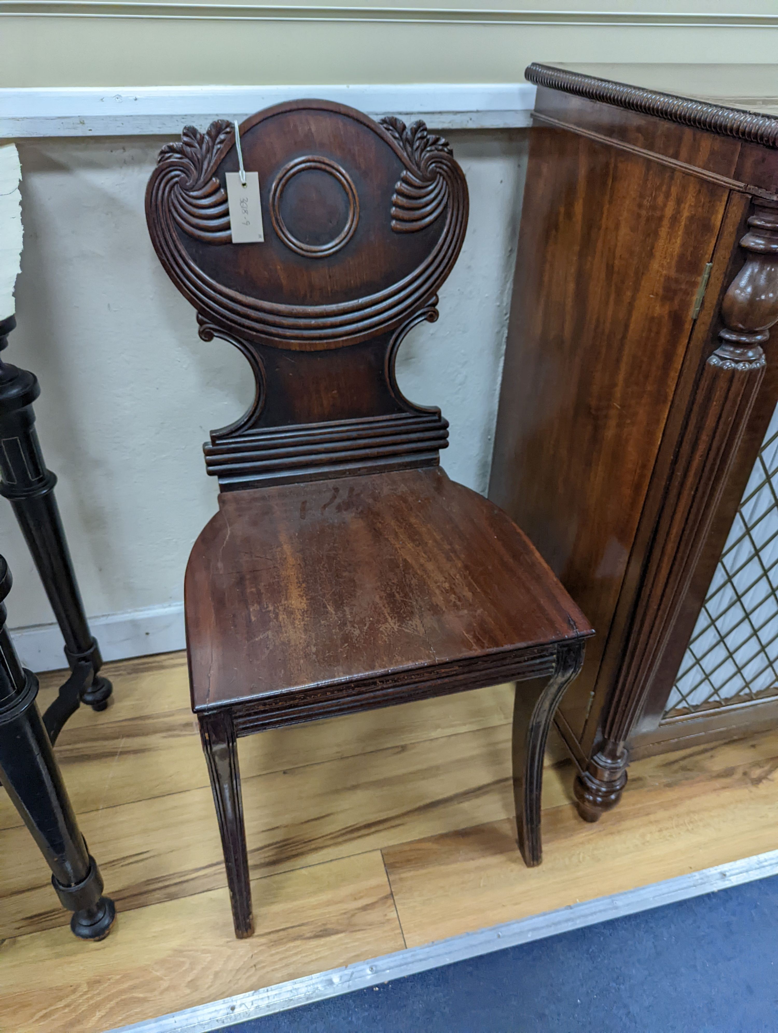 A pair of Regency mahogany sabre leg hall chairs